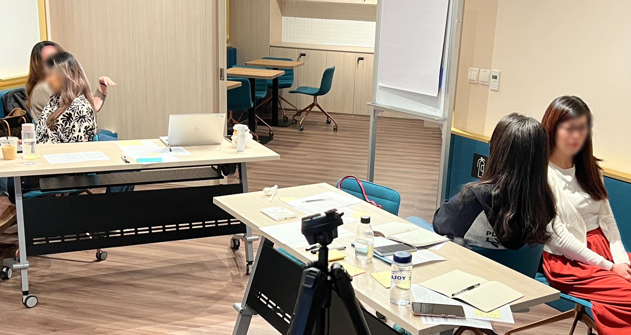Two groups of two ladies, each sitting side-by-side. One of each pair is talking, while the other is listening intently.